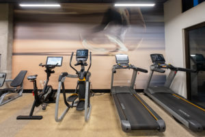 Stair machines, treadmills and a exercise bike in a fitness room.